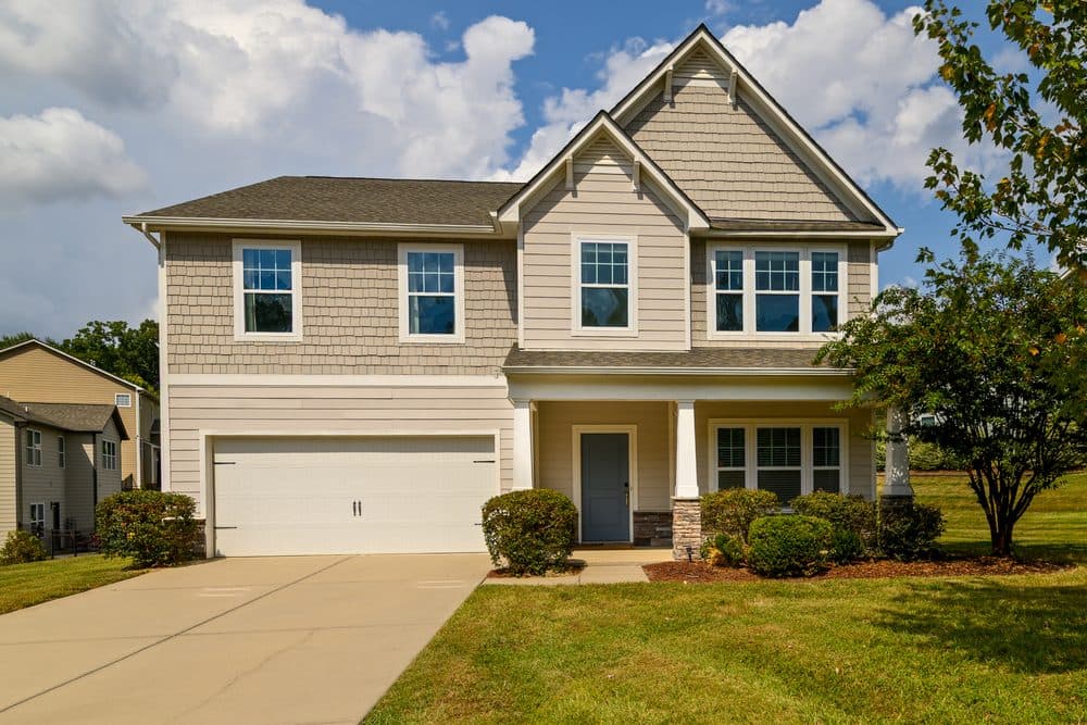 Two-story craftsman with stone porch columns and a wide lawn, Indian Land, SC listing