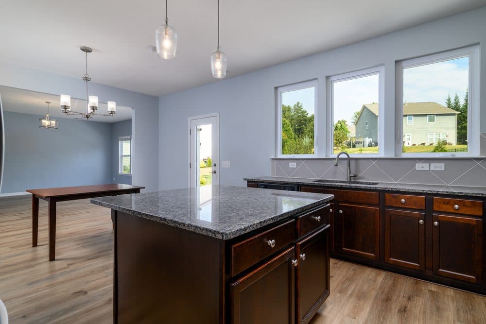 Kitchen with a granite island, dark cabinets and windows over the sink, Indian Land, SC listing